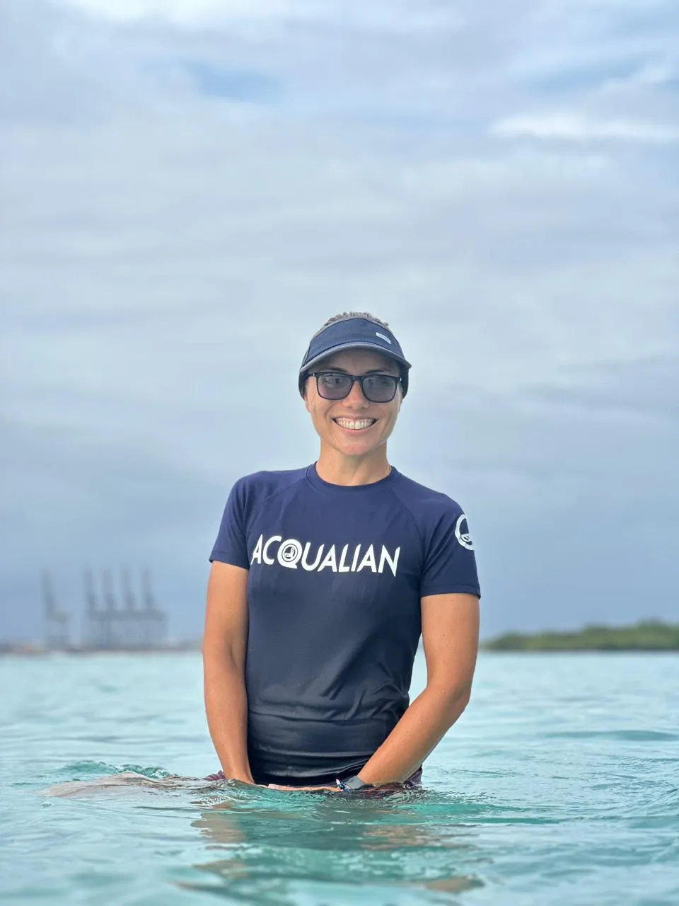 Instructora de Acqualian con la camiseta de la escuela, de pie en el mar